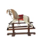 Dapple grey rocking horse of traditional style set on a stained pine and iron mounted base, 111cm