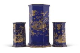 A garniture of Cauldon early 20th Century vases of faceted shape with gilt chinoiserie design