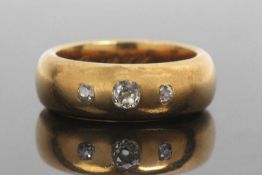 Antique three stone diamond ring featuring three graduated old cut diamonds in a plain polished wide