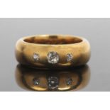 Antique three stone diamond ring featuring three graduated old cut diamonds in a plain polished wide