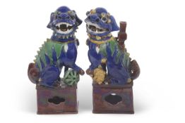 A pair of Chinese dogs of fo or lions on square brown bases with blue Maiolica type glazes, 25cm