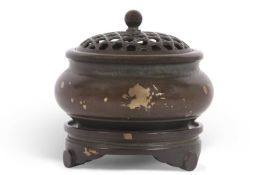 A Chinese bronze gilt gold splashed censer on circular stand with pierced cover