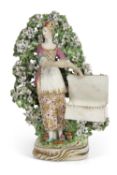 A Chelsea Derby sweetmeat figure of a young lady standing against bocage, 21cm high