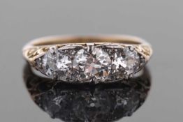 A three stone diamond ring, the three round old mine cut diamonds, set with diamond highlights,