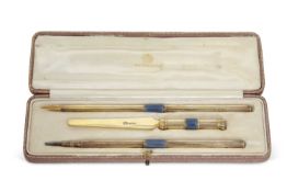 A George V silver gilt and enamel desk pen set comprising a propelling pencil, dip pen and a