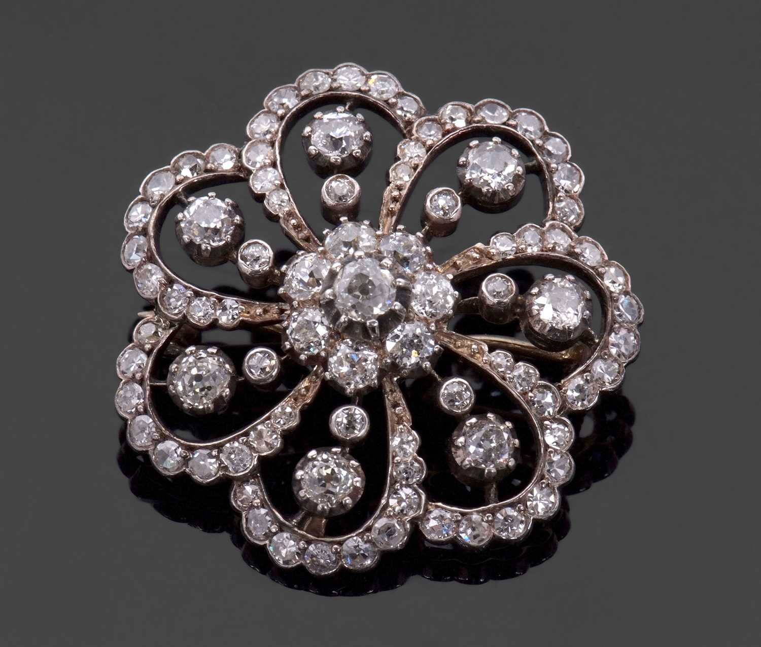 A late 19th/early 20th century diamond brooch, the central diamond flowerhead cluster, surrounded by