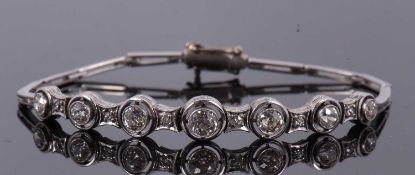 An early 20th century diamond bracelet, the seven round old cut diamonds,in collet and millegrain