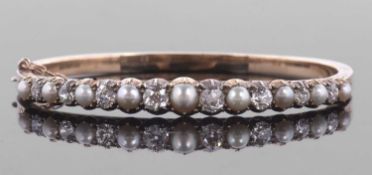 A 'pearl' and diamond bangle, the alternating 'pearls' in closed backs, with claw mounted old mine