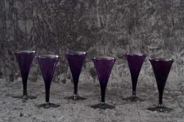 A rare set of six George III Bristol amethyst wine glasses each with drawn trumpet bowl with everted