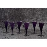 A rare set of six George III Bristol amethyst wine glasses each with drawn trumpet bowl with everted