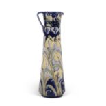 A Florian ware ewer with tube lined design of tulips picked out in yellow on a blue ground within