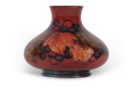A Moorcroft vase of compressed ovoid form in the leaf and berry pattern with a flambe glaze