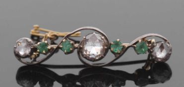 An emerald and diamond brooch, set with a central rose cut diamond, approx. 7.6mm diameter x 2.2mm