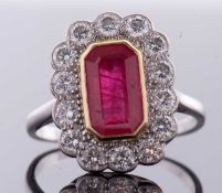 An 18ct ruby and diamond ring, the octagonal step cut ruby, approx. 11 x 6 x 4.1mm, collet mounted