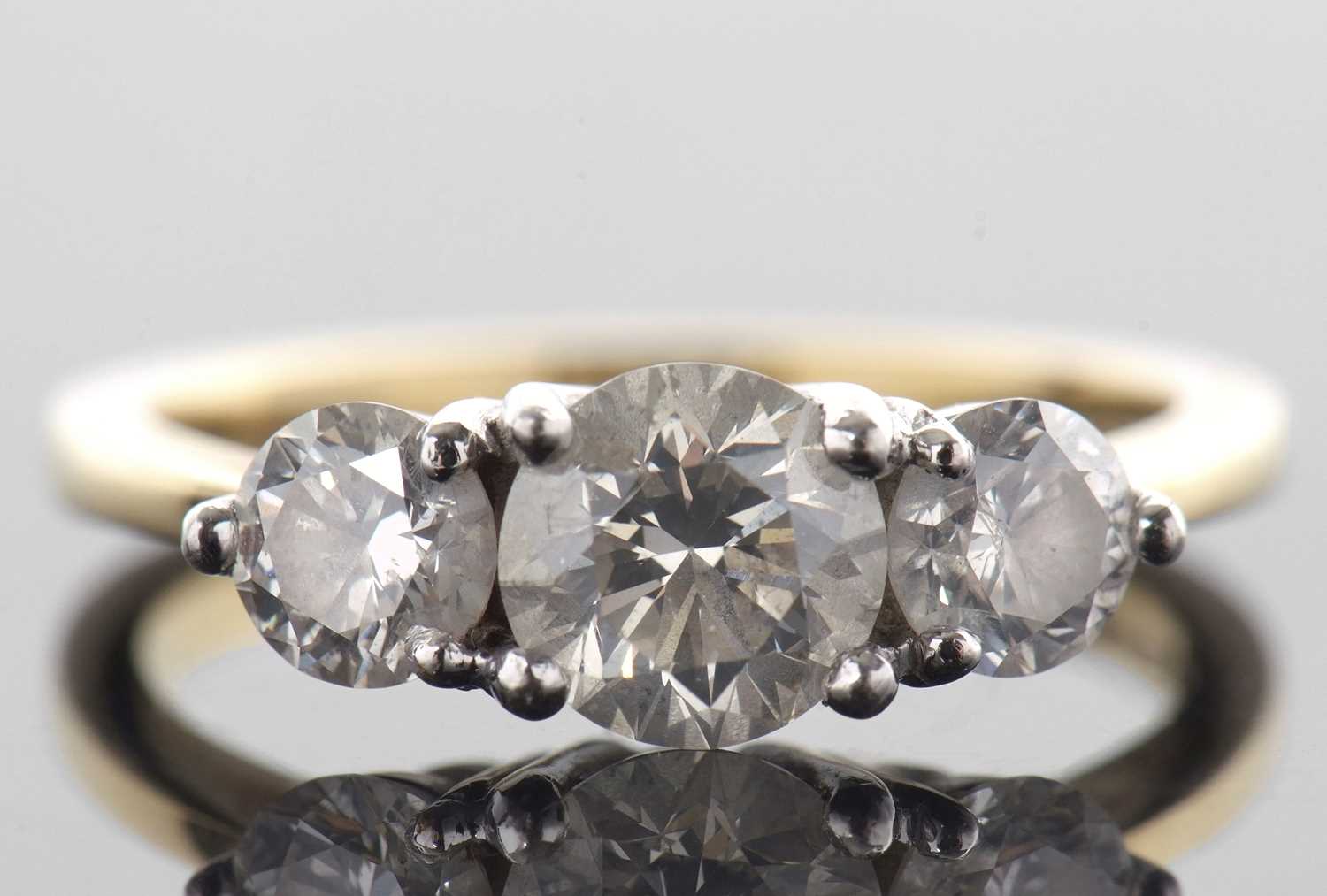 An 18ct three stone diamond ring, the three slightly graudated round brilliant cut diamonds, total - Image 2 of 11