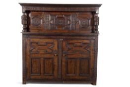 A large 17th Century oak court cupboard with moulded cornice over a top section with two panelled