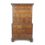 An early 18th Century walnut veneered chest on chest with moulded cornice over three short drawers