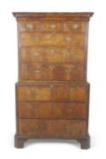 An early 18th Century walnut veneered chest on chest with moulded cornice over three short drawers