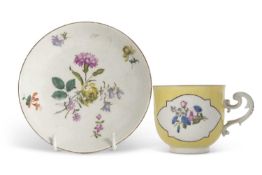 A Meissen porcelain cup and saucer circa 1750, the yellow ground with panels of Deutsche Blumen, the