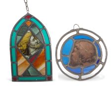 A stained and leaded glass panel in the form of an arch the centre decorated with the head of a
