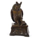 A ceramic model of a "Wise Owl" perched on an open book with a scholar at his studies around the