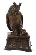 A ceramic model of a "Wise Owl" perched on an open book with a scholar at his studies around the