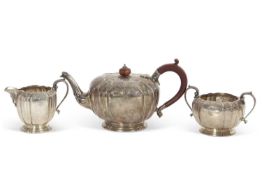 An Elizabeth II silver three piece tea set comprising a teapot, twin handled sugar bowl and milk jug