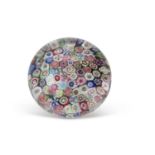 A Clichy Millefiori paperweight, the base with a blue and white striped design