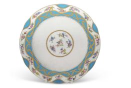 An 18th Century Sevres plate the centre decorated with scattered floral sprays within a gilt