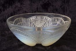 A 1930's Lalique bowl in the Coquilles pattern with shell moulded opalescent feet, 21cm diameter,