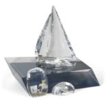 A Swarovski model of a yacht on fitted stand together with two small Swarovski paperweights, one