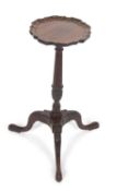 A small George III wine table or kettle stand, the top with pie crust edge, raised on a fluted