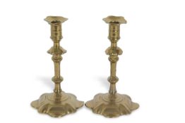 A pair of 18th Century brass candlesticks with petal formed spreading bases, 22cm high Possible