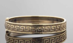 A 9ct Greek key decorated hinged bangle, the two tone bangle with textured background and raised