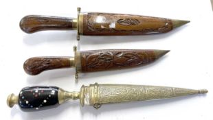 A trio of ornately decorated/carved short daggers or kukris in scabbards
