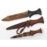 Three North African daggers/knives with carved turned handles and leather and python skin tribal