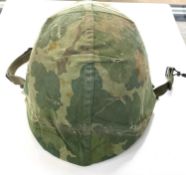 Mid 20th Century American Vietnam era military M1 helmet with liner and reversable oak camoflauge