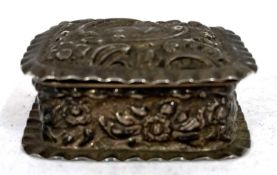 A small late Victorian silver pill box of rectangular form embossed all over with scrolls and