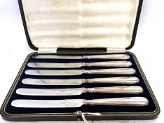 Cased set of six stainless steel bladed knives each with white metal handles in fitted case