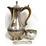 A Victorian silver hot water jug of baluster form with part fluted detail on a spreading foot,