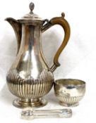 A Victorian silver hot water jug of baluster form with part fluted detail on a spreading foot,