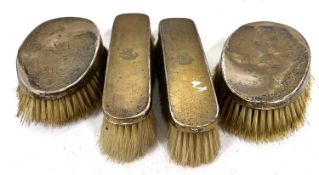 Four Edwardian silver backed hair/clothes brushes, each engraved with an armorial and hallmarked for