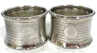Pair of George V silver serviette rings both chased with a wavey line design around a vacant