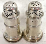 A pair of Victorian silver peppers of lighthouse form with pull off pierced lids and reeded edges on