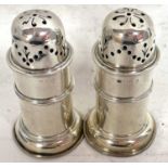 A pair of Victorian silver peppers of lighthouse form with pull off pierced lids and reeded edges on