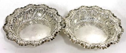 A pair of Victorian embossed shallow dishes of round form decorated with trailing scrolls etc,