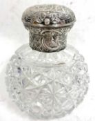 A late Victorian scent bottle, having cut glass globular body with a hinged silver embossed lid