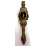 An antique treen box wood nut cracker, a carved figure sitting astride a barrel with screw handle,