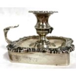 An Edwardian silver chamber stick of square form with a shell and gadrooned border, scroll leaf