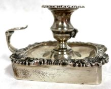 An Edwardian silver chamber stick of square form with a shell and gadrooned border, scroll leaf